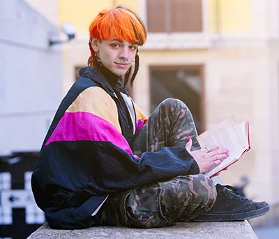 A reader sitting outside with an open book